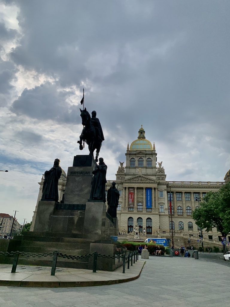 Teatro Nacional de Praga junto al río Moldava con estatua al frente y fachada neorrenacentista